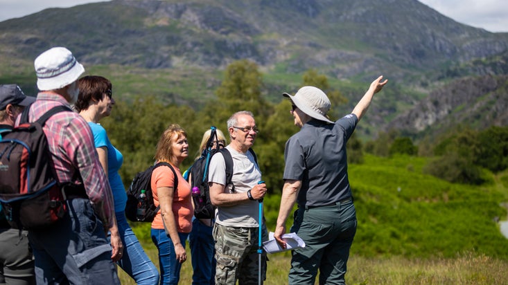 A group of walkers with a volunteer guide at Tarn Hows in Cumbria